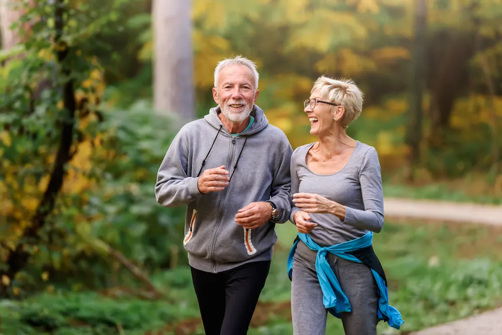 Smiling senior couple jogging in the park